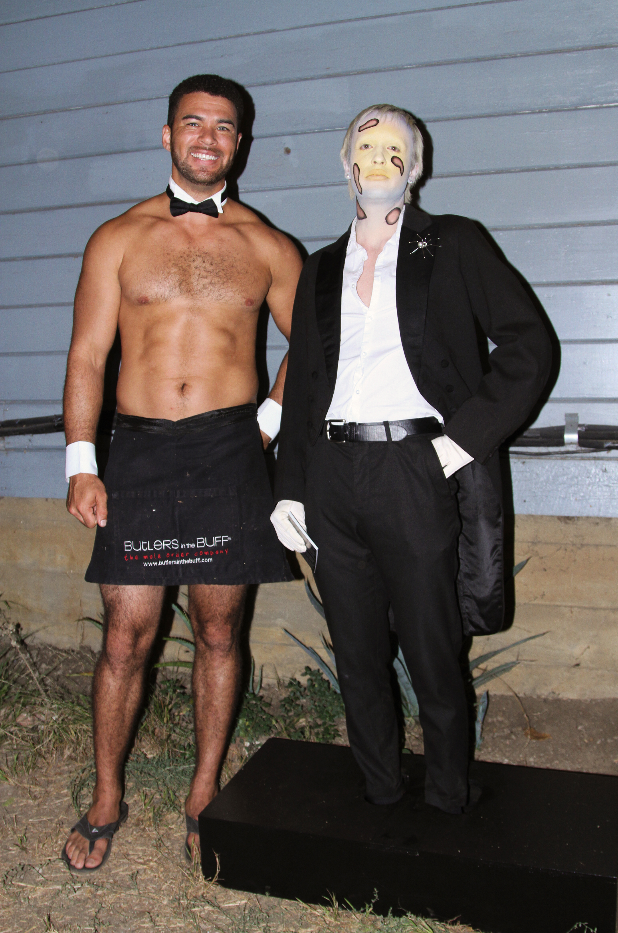 Jesse in facepaint standing in a black box around his feet next to a shirtless male butler